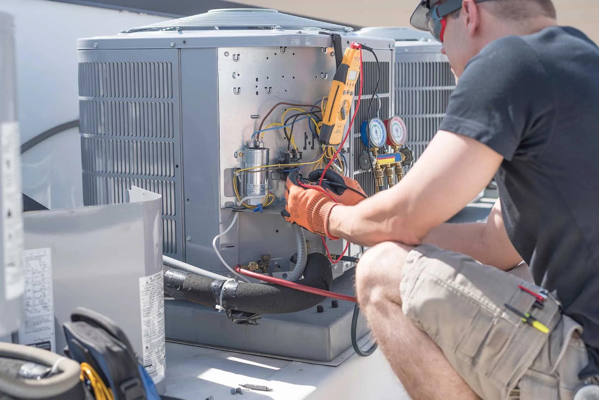HVAC technician diagnosing an outdoor air conditioning system